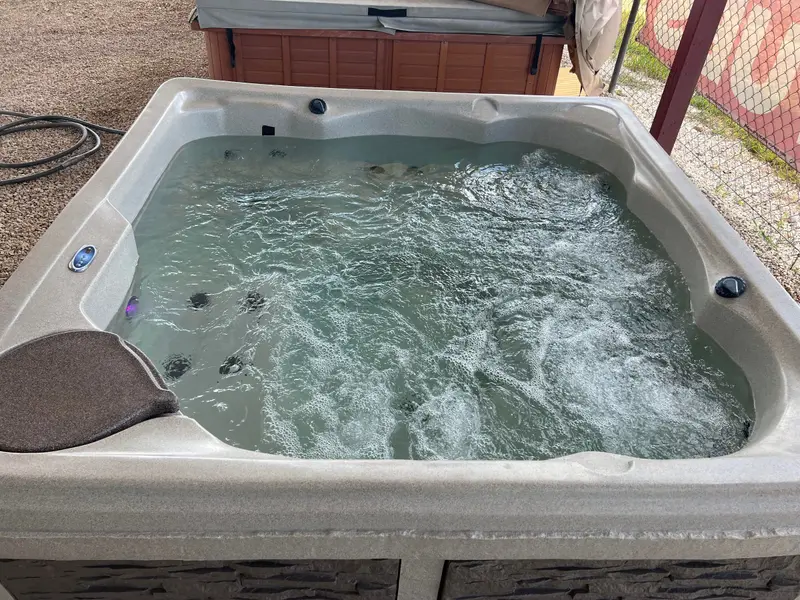 Tan-shell hot tub running on the lot