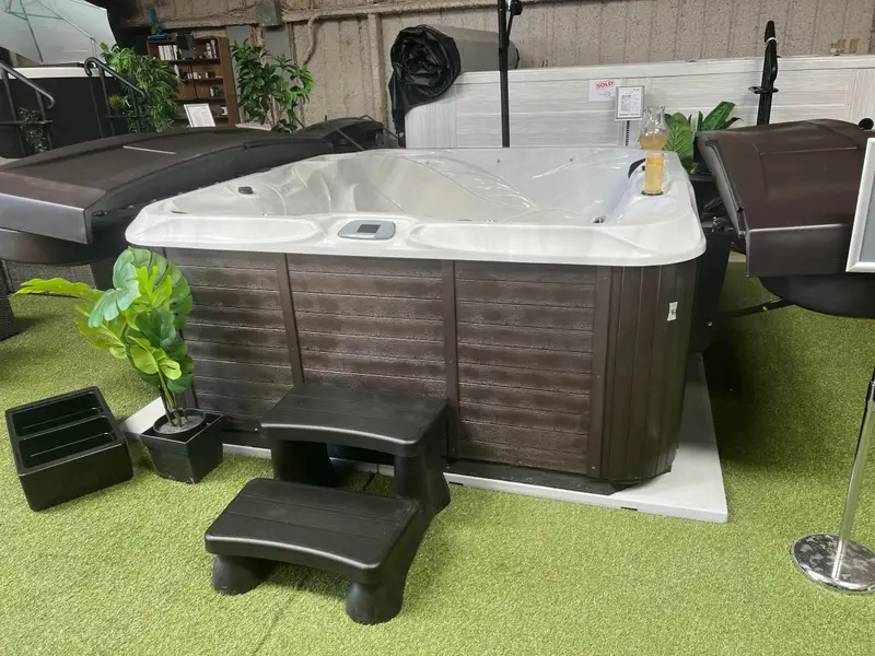 A hot tub with steps on display in the Longhorn Hot Tubs showroom