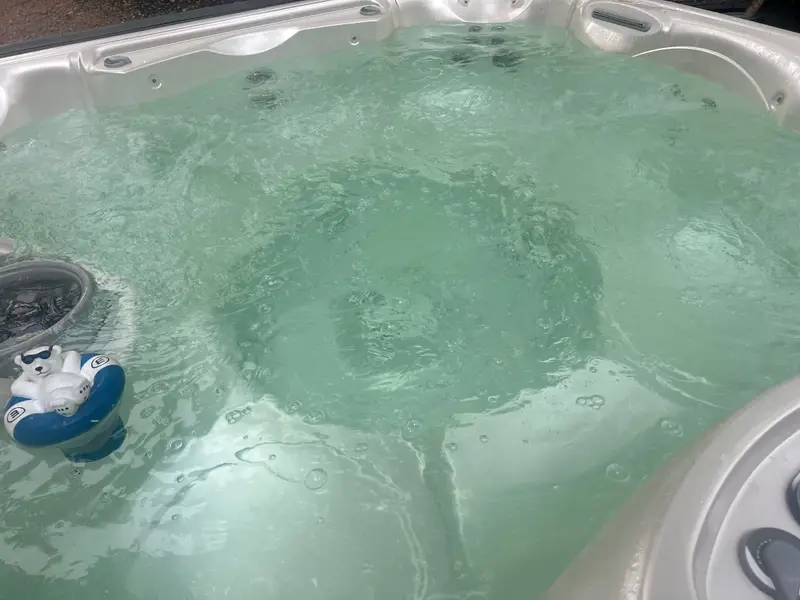 Hot tub water with a floating chemical dispenser